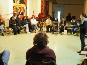 Patti educativi di comunità - Il workshop organizzato da ActionAid e Uds, un'assemblea in cerchio discute mentre una ragazza in piedi interviene