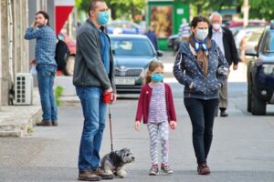 foto di una famiglia a passeggio con la mascherina