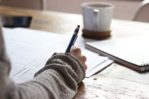 Giovanni Fosti (Fondazione Cariplo): "Serve il pane, ma servono anche le rose: daremo 2.500 tutor ai ragazzi in crisi" - Un ragazzo sta facendo i compiti e si vede solo la mano destra che scrive sul foglio