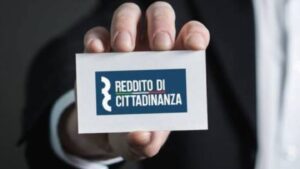La mano di un uomo in giacca e cravatta mostra un biglietto da visita del reddito di cittadinanza