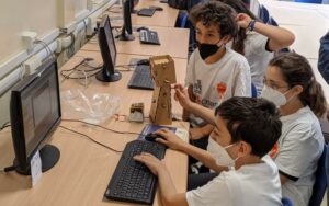 Bambini che utilizzano un computer. Foto del progetto Open Space promosso da Fondazione Mondo Digitale