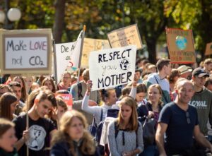 Immagine di copertina che descrive i legami sempre più forti tra cambiamento climatico e welfare, con al centro una manifestazione per il clima