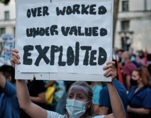 Una donna protesta per salari più giusti. Immagine di copertina dell'articolo di Luca Furfaro "Salario minimo, la punta dell’iceberg di un tema molto più ampio" pubblicato su Secondo Welfare