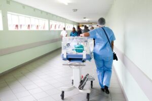 Corridoio di un ospedale con infermiere. Immagine di copertina di un articolo di Luciano Pallini su cosa pensano gli italiani del sistema sanitario italiano, basato su dati della European Health Interview Survey della Commissione UE. L'articolo è pubblicato su Secondo Welfare.