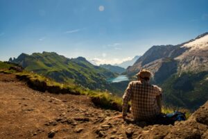 Un uomo guarda le montagne a Canazei, in Treninto. Immagine di copertina di un articolo di Secondo Welfare su Invecchiamento e non autosufficienza_la via trentina per creare un secondo pilastro mutualistico