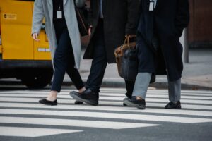 Colleghi Che Camminano All'incrocio In Città. Immagine di copertina di un articolo di Secondo Welfare sulla certificazione della parità di genere nelle aziende italiane.