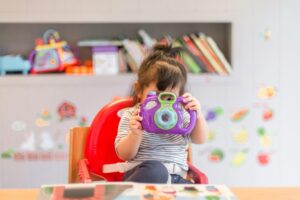 bambina con macchina fotografica giocattolo. Foto utilizzata come immagine di copertina per un articolo di Percorsi di secondo welfare sul Fondo per la povertà educativa che continuerà a funzionare grazie al decreto Milleproroghe, ma con meno risorse.