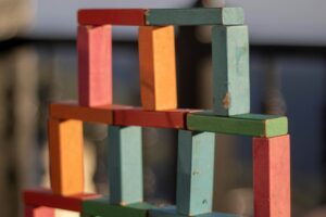 costruzione di blocchi di legno multicolore. Immagine di copertina di un articolo di Percorsi di secondo welfare sulla filantropia basata sulla fiducia scritto da Carola Carazzone di Assifero