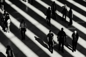 foto in scala di grigi di persone sul marciapiede bianco. Immagine di copertina di un articolo di Secondo Welfare su cosa succede quando chi pur avendo diritto ad un benefit pubblico non lo riceve.