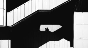 Donne sulle scale foto in bianco e nero. Immagine di copertina di un articolo di Percorsi di secondo welfare sul progetto CHECk, il progetto europeo per migliorare le politiche di conciliazione vita-lavoro, contrastare gli stereotipi di genere e promuovere buone pratiche tra imprese e istituzioni in Italia, Lituania e Spagna.