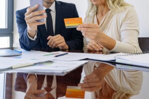 Due persone usano una carta di debito. Immagine di copertina di un articolo di Secondo Welfare sul tema "Welfare aziendale e fringe benefit: due novità che forse vi sono sfuggite"
