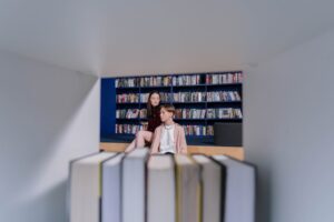 foto di due ragazzi in biblioteca. immagine di copertina di un articolo di Percorsi di secondo welfare su vantaggi e difficoltà che si creano nel rapporto tra i luoghi della cultura e gli adolescenti
