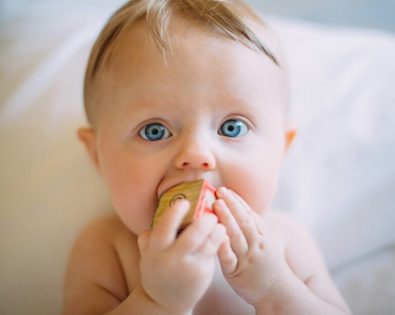Bambino piccolo con un gioco in bocca