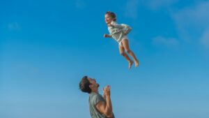 papà e bambina che giocano. Foto di copertina di un articolo di Percorsi di secondo welfare sulla genitorialità.
