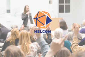 Persone che lavorano in gruppo e alzano la mano, con il logo di Welcom - Manager del Welfare di Comunità. Immagine di copertina di un articolo di Percorsi di secondo welfare sulle cinque posture per il lavoro sociale di comunità