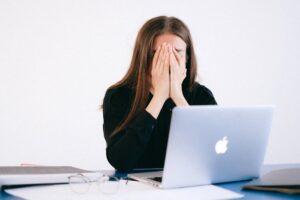 ragazza rassegnata al computer. Immagine di copertina per un articolo di Percorsi di secondo welfare sul welfare aziendale come soluzione al fatto che le imprese italiane faticano a trattenere i talenti
