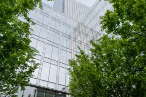 Foto di un edificio e degli alberi. Immagine di copertina di un articolo di Percorsi di secondo welfare sul ruolo che il welfare aziendale può avere nella rendicontazione ESG