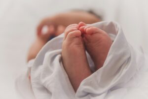 Foto dei piedi di un neonato. Immagine di copertina di un articolo di Percorsi di Secondo Welfare sul perché a Bolzano e Caserta fanno più figli, per capirlo dati su natalità, occupazione femminile e servizi per l’infanzia.
