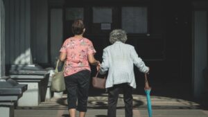 Signore che camminano di spalle. immagine di copertina di un articolo di Percorsi di Secondo Welfare su L'associazione europea dei caregiver ha lanciato un appello per riconoscere il loro ruolo a livello sistemico. Ce ne parla Loredana Ligabue.