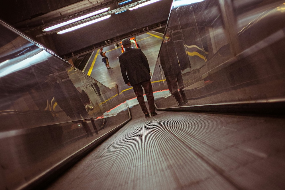 Una persona anziana scende una scala mobile. Immagine di un articolo di Percorsi di Secondo Welfare sui nessi tra mobilità e politiche sociali