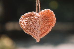 Cuore all'uncinetto, immagine di copertina di un articolo di Percorsi di Secondo Welfare su il Rapporto finale del progetto Tessere la Salute, presentato a Biella il 4 dicembre scorso. Il documento fotografa tre anni di sperimentazione di welfare di comunità nel Biellese, raccontando i risultati della sperimentazione tra dinamiche di rete, relazioni di prossimità e tavoli territoriali. Che ora sono orientati a diventare infrastruttura civica permanente.