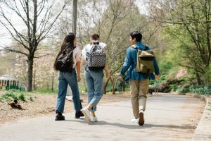 Tra giovani camminano insieme in un parco. Immagine di copertina di un articolo pubblicato su Percorsi di Secondo Welfare che parla dei progetti Progetti START, MAYBE e YEP! dedicati alla transizione dei giovani verso l'età adulta