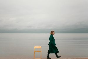 Ragazza che cammina da sola in riva al mare. Immagine di copertina di un articolo di Percorsi di Secondo Welfare su Come vede la povertà chi fa volontariato in Caritas