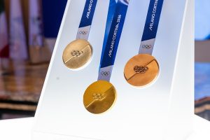 Le medaglie olimpiche di Milano Cortina 2026. Immagine di copertina di un articolo di Percorsi di Secondo Welfare sull'accordo tra Banco Alimentare e Fondazione Milano Cortina contro lo spreco di cibo alle Olimpiadi e Paralimpiadi