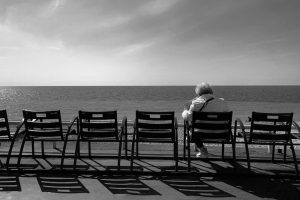 signora anziana seduta davanti al mare. Immagine di copertina di un articolo di Percorsi di Secondo Welfare sul ruolo dei ruolo dei broker nella società che invecchia