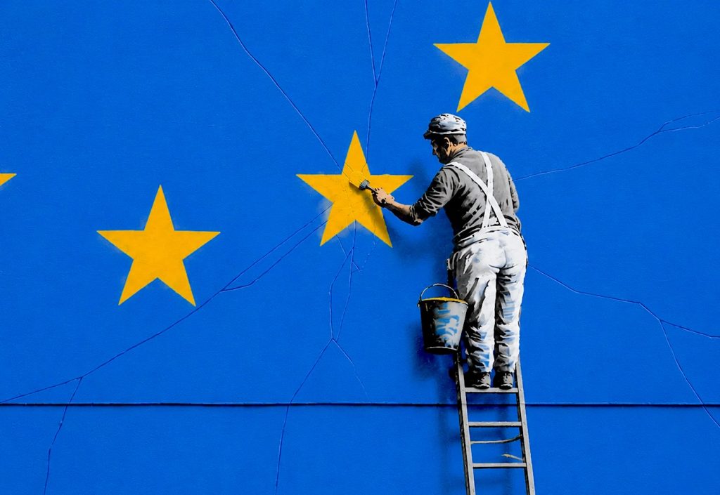 Un uomo colora una stella della bandiera UE. Immagine di un articolo di Percorsi di Secondo Welfare sulla Strategia europea contro la povertà