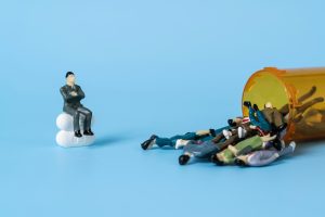 Un omino seduto su delle pastiglie guarda altri omini che escono da un barattolo di medicinali. Immagine di copertina di un articolo di Percorsi di Secondo Welfare sulla nuova governance del Sistema Sanitario Nazionale