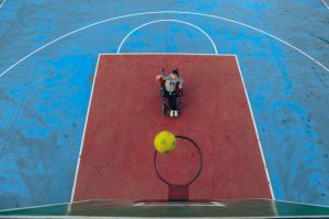 Un ragazzino in carrozzina fa canestro su un campo da basket. Immagine di copertina du un articolo di Percorsi di Secondo Welfare sulla sperimentazione del Progetto di Vita a Catanzaro